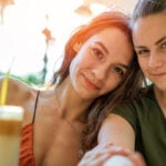 Two woman smiling in camera as symbol for lesbian relationship