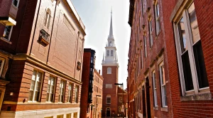 Old North Church in Boston, next to two red brick buildings (Generated with AI)