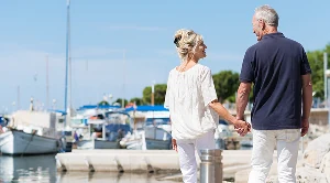 A couple walking hand in hand at the harbour. (Generated with AI)