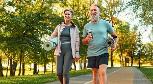 A couple walk the streets with yoga mats under their arms, on their way to an outdoor workout. (Generated with AI)