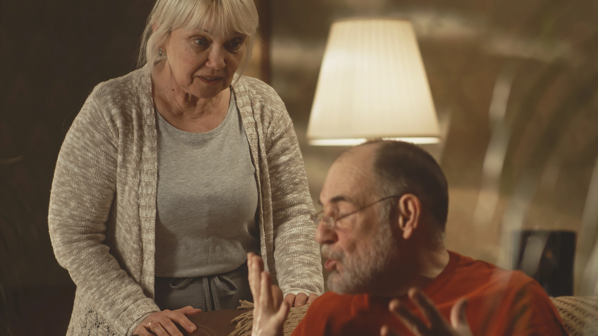 Elderly couple having a serious conversation at home.