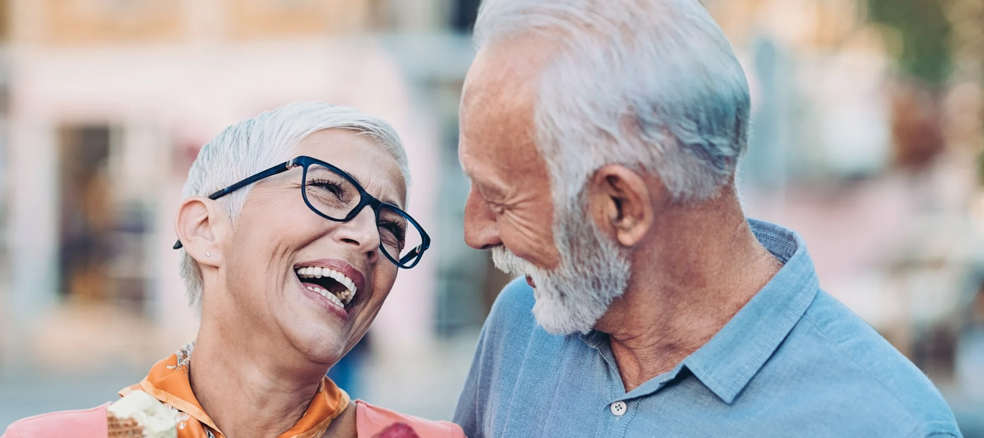 Senior couple enjoying ice cream and laughing together.