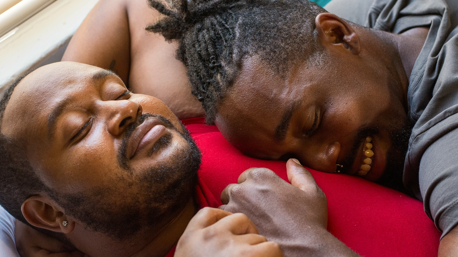 Two men cuddling each other.